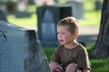 child crying in front of tombstone child crying in front of tombstone